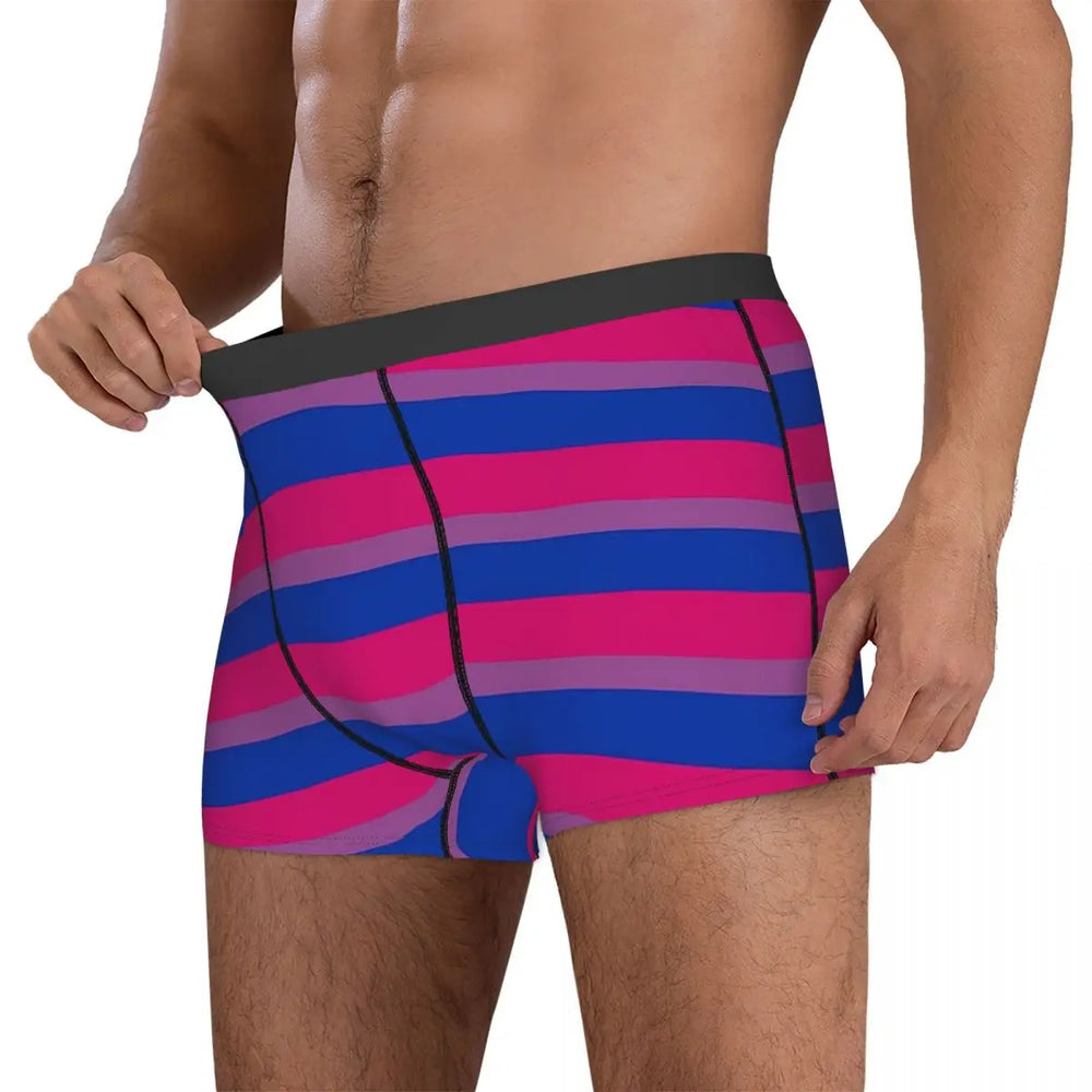 Cropped model wearing pink, purple, and blue striped boxer briefs, pulling the waistband outward