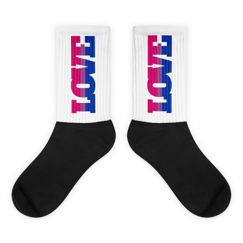 Pair of black-and-white crew socks with pink-and-blue vertical graphics on the cuffs