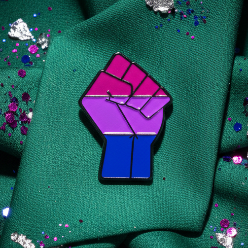 Bisexual pride power-fist enamel pin on green fabric with scattered sequins