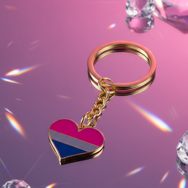 Bisexual pride heart keychain with pink, purple, and blue stripes on a reflective surface