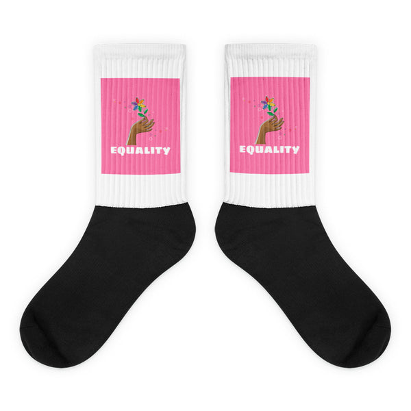 Pair of black socks with white ribbed cuffs, pink panels, and “EQUALITY” text