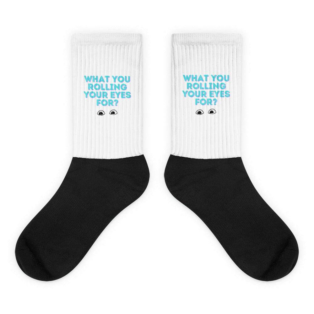 Pair of black-and-white ribbed socks reading “WHAT YOU ROLLING YOUR EYES FOR?”