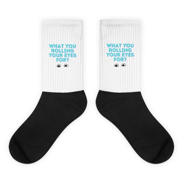 Pair of black-and-white ribbed socks reading “WHAT YOU ROLLING YOUR EYES FOR?”