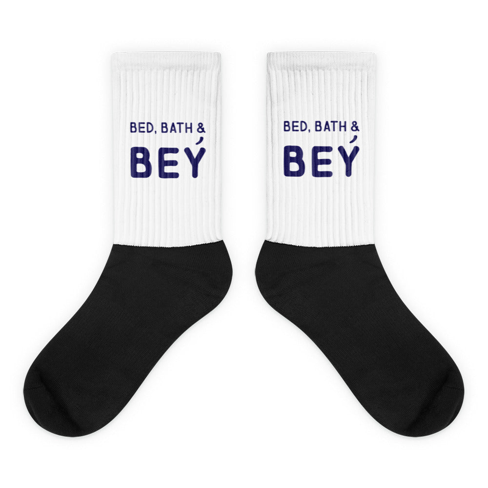 Pair of white ribbed socks with black feet and navy “BED, BATH & BEY” text