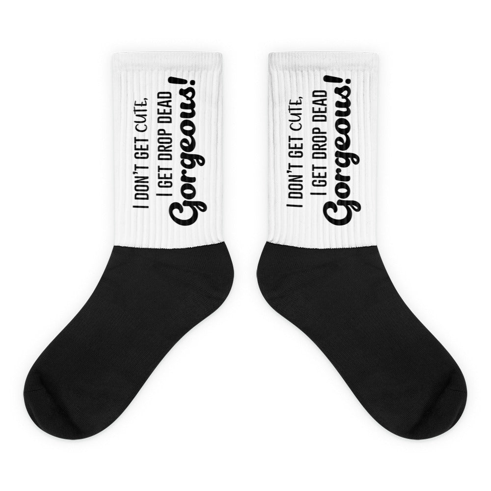 Pair of black-and-white crew socks reading “I don’t get cute, I get drop dead gorgeous!”