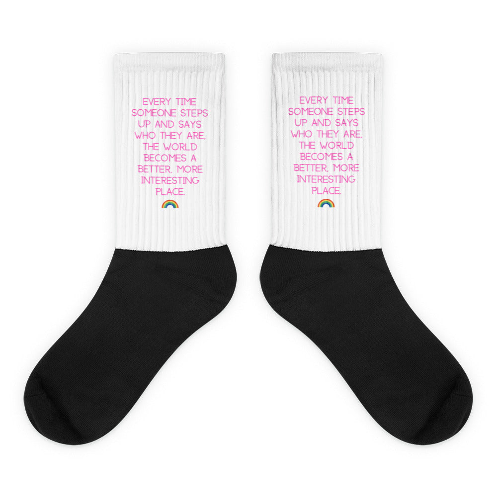Pair of black-and-white crew socks with pink quote text and small rainbow icons