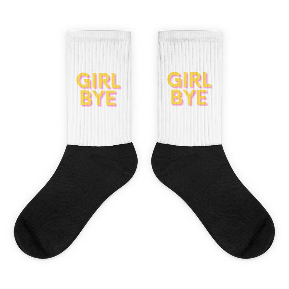 Pair of black-and-white crew socks with pink-and-yellow “GIRL BYE” text