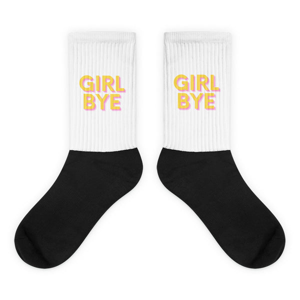 Pair of black-and-white crew socks with pink-and-yellow “GIRL BYE” text