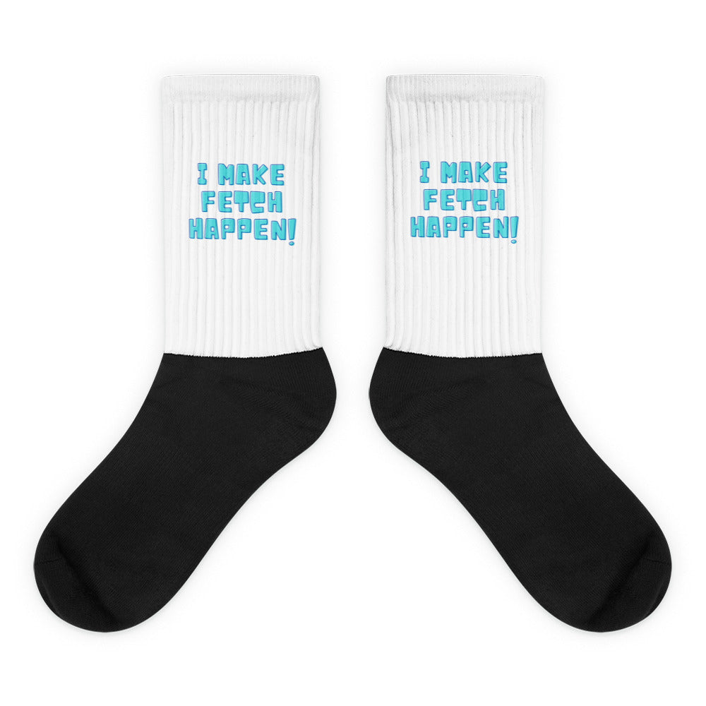 Pair of black-and-white crew socks reading “I MAKE FETCH HAPPEN!” in blue