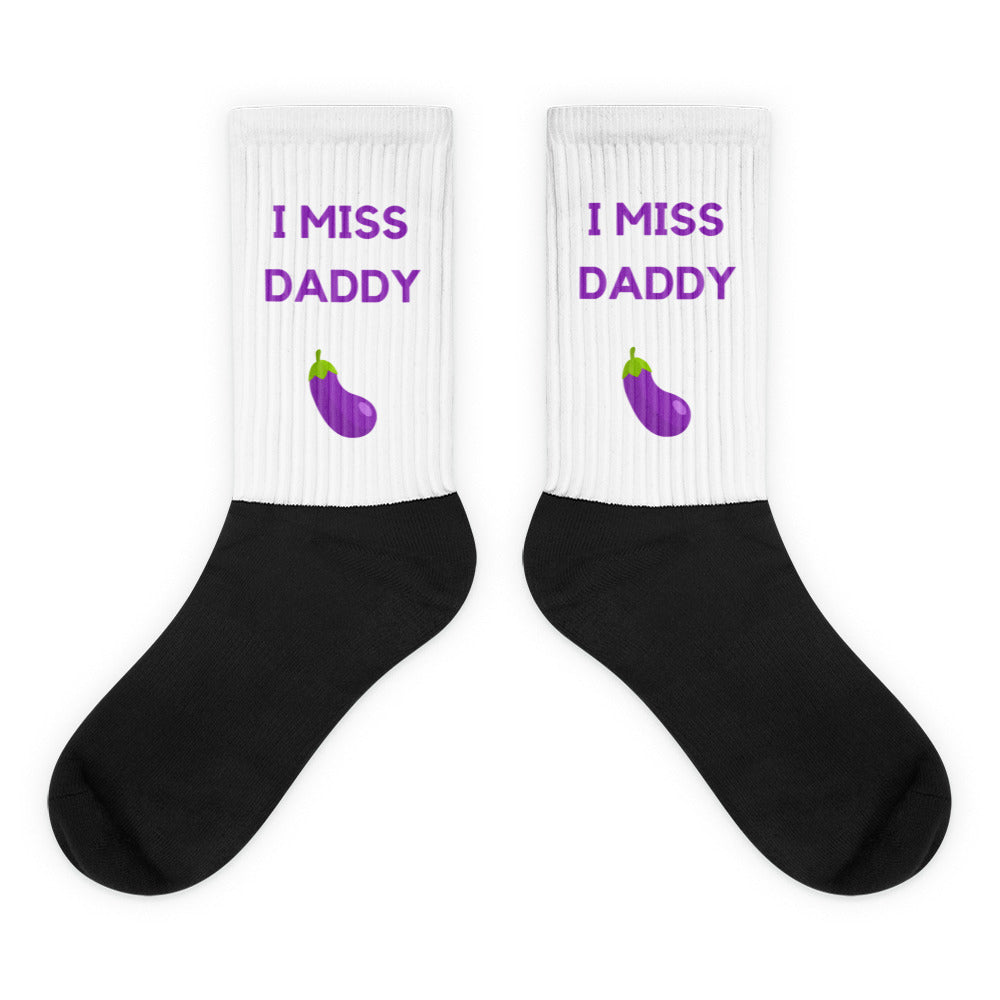 Pair of black-and-white crew socks reading “I MISS DADDY” with purple eggplant graphics