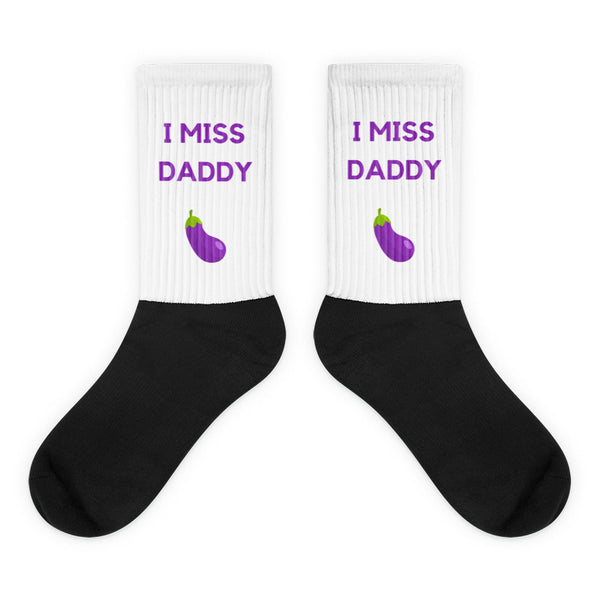 Pair of black-and-white crew socks reading “I MISS DADDY” with purple eggplant graphics