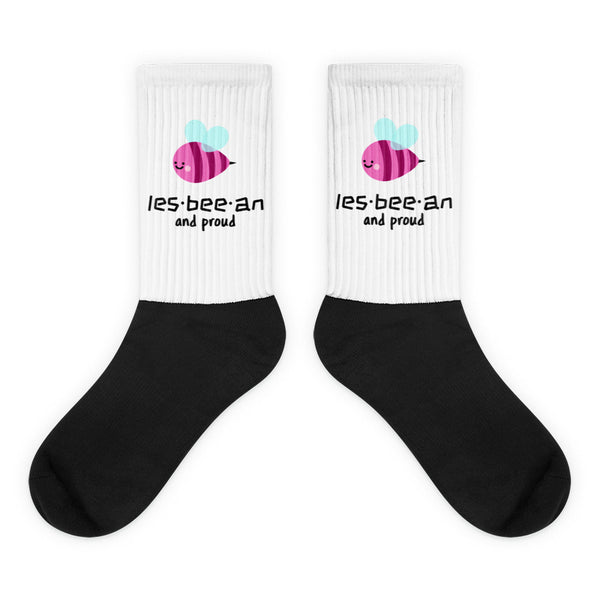 Pair of white-and-black crew socks with pink bee graphics and “les·bee·an and proud” text