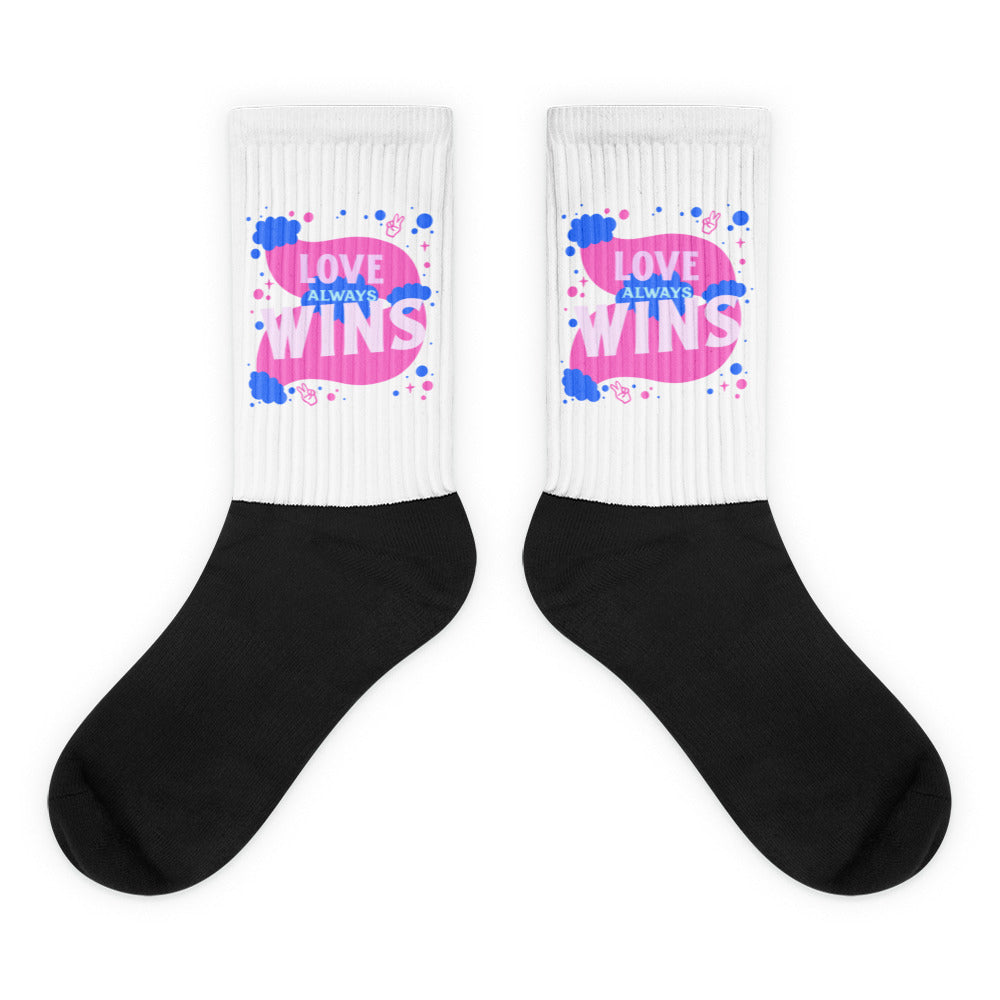 Pair of black-and-white crew socks with colorful “LOVE ALWAYS WINS” graphics