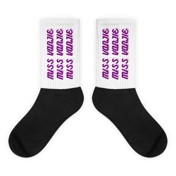 Pair of black-and-white socks with purple “Miss Vanjie” text repeated on the cuffs