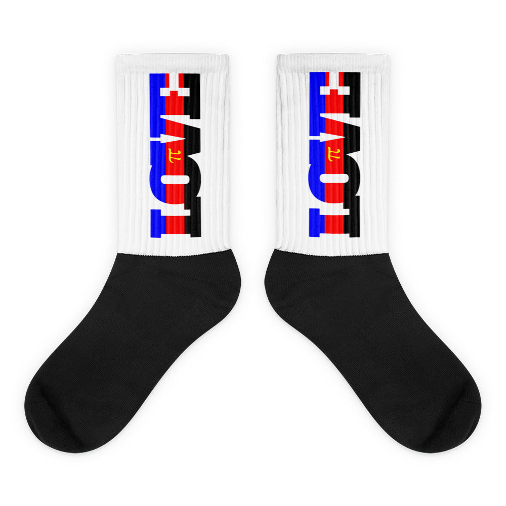 Pair of black and white crew socks with colorful vertical graphics on the ribbed cuffs
