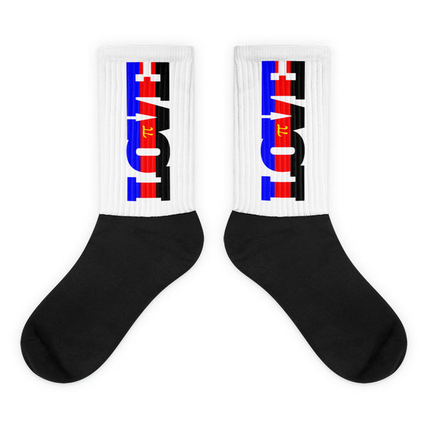 Pair of black and white crew socks with colorful vertical graphics on the ribbed cuffs