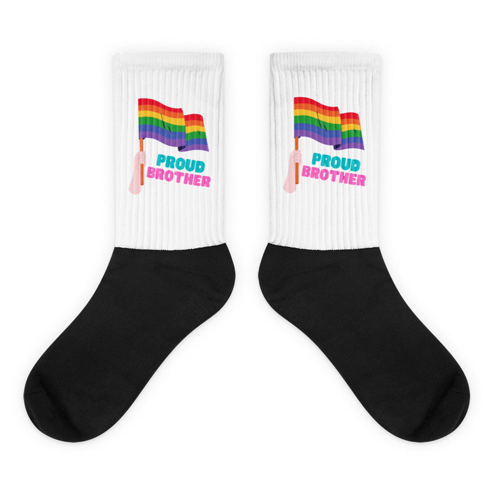 Pair of black-and-white socks with rainbow flags and “PROUD BROTHER” text
