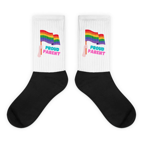 Pair of white-and-black socks with rainbow flags and “PROUD PARENT” text