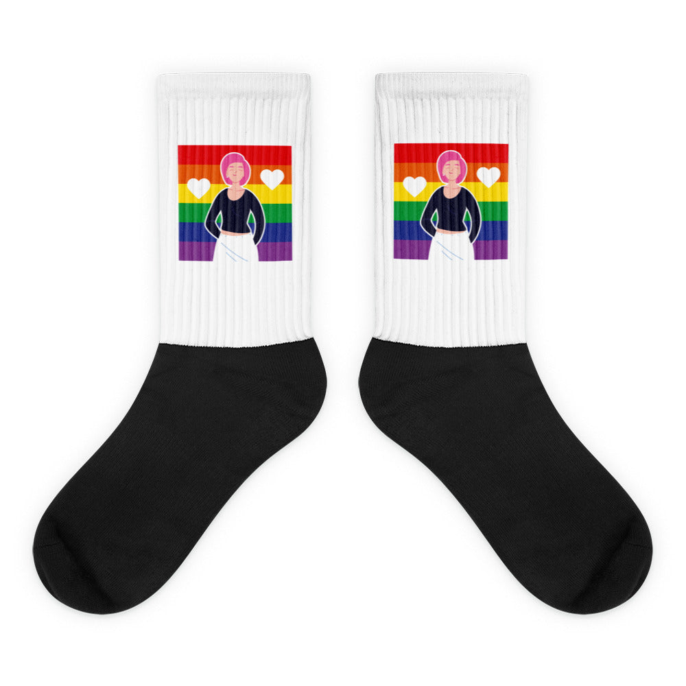 Pair of black-and-white crew socks with rainbow flags, hearts, and a cartoon figure