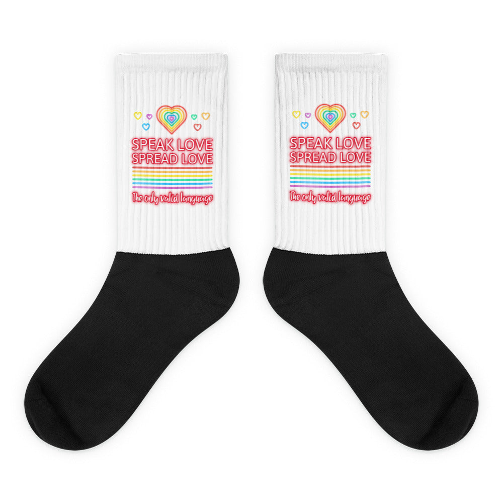 Pair of black-and-white crew socks with rainbow hearts and “SPEAK LOVE SPREAD LOVE” text
