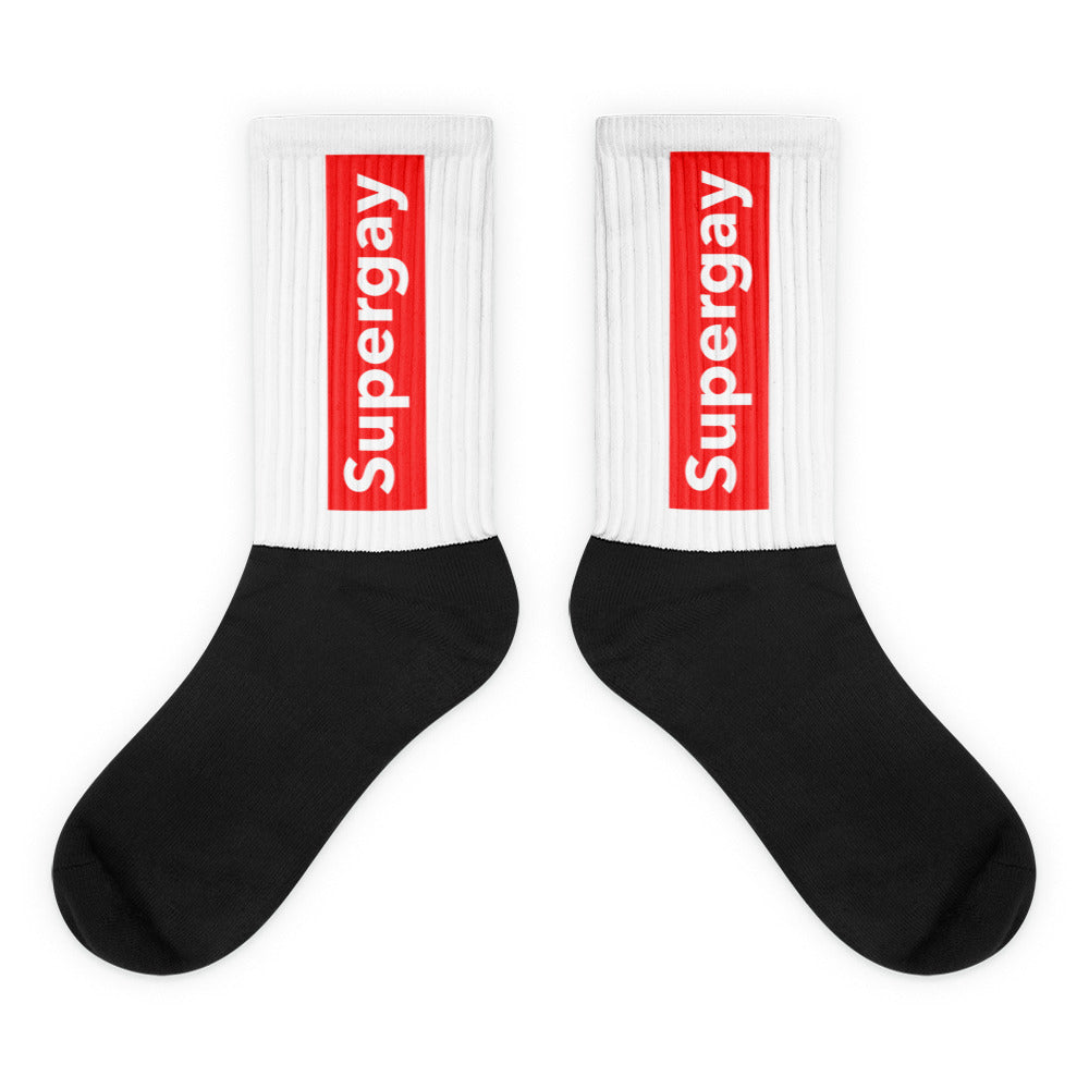 Pair of black-and-white crew socks with red vertical “Supergay” labels