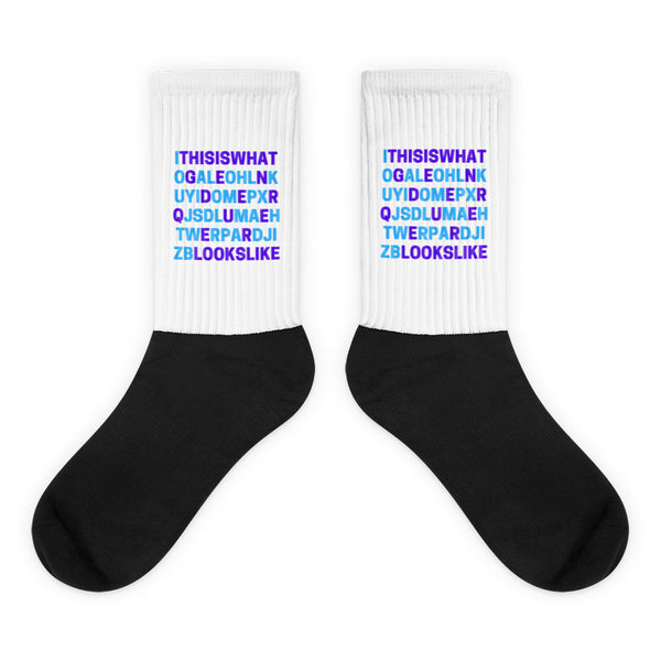 Pair of black-and-white socks with colorful text reading “This Is What Genderqueer Looks Like”