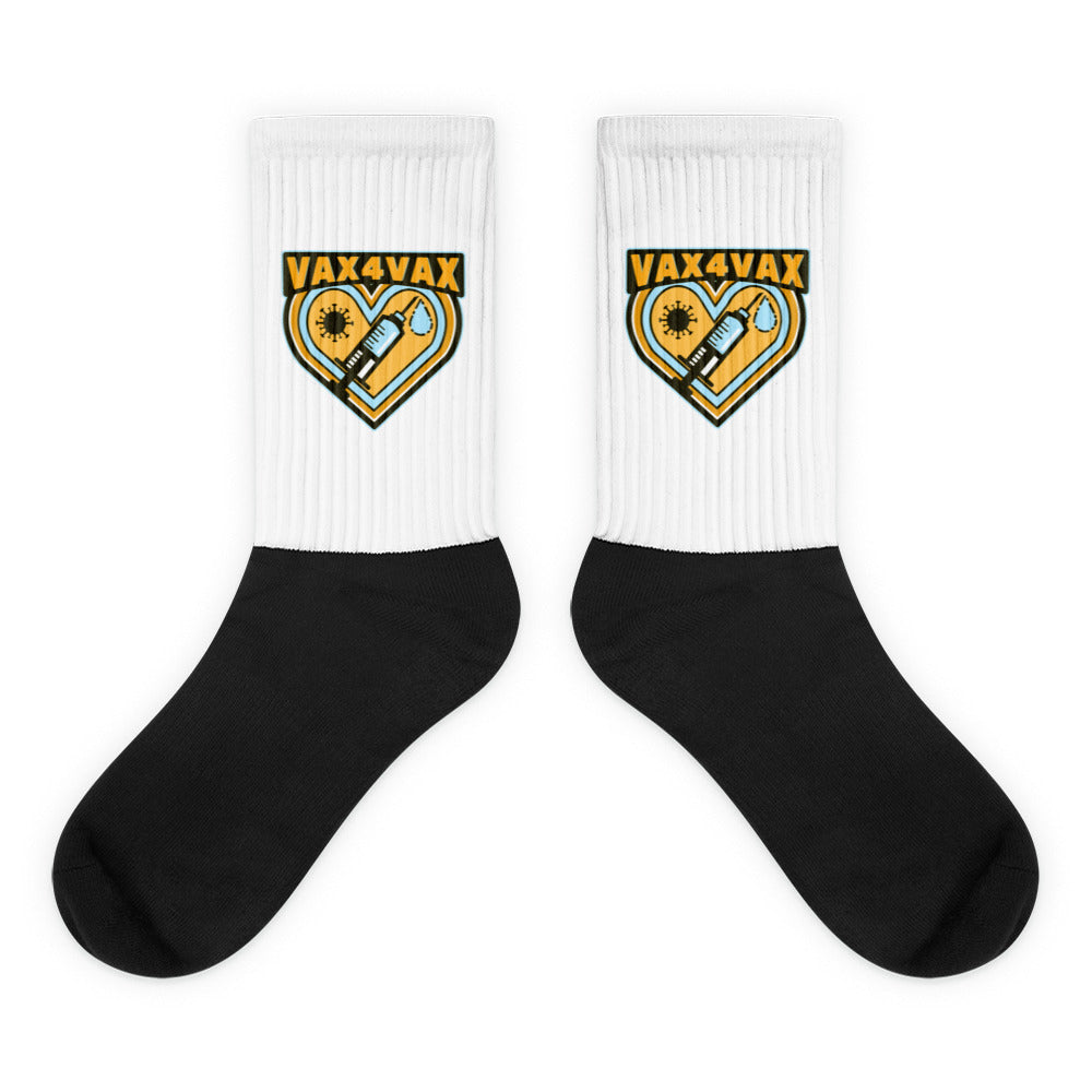 Pair of black-and-white socks with yellow “VAX 4 VAX” heart-and-syringe graphics