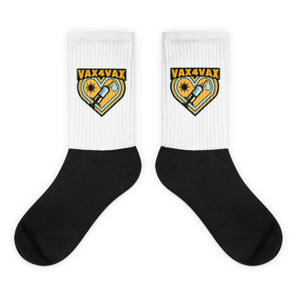 Vax 4 Vax Socks featuring a bold yellow-and-black emblem with a heart, syringe, virus, and liquid drop on a chic black foot and white ribbed leg, celebrating LGBTQIA+ pride and self-expression.