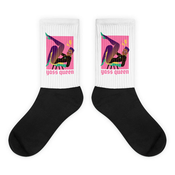 Yass Queen Socks feature a white upper with pop-art graphics of a purple figure and yass queen text, black foot section, embodying vibrant self-expression, LGBTQIA+ pride, and playful empowerment.