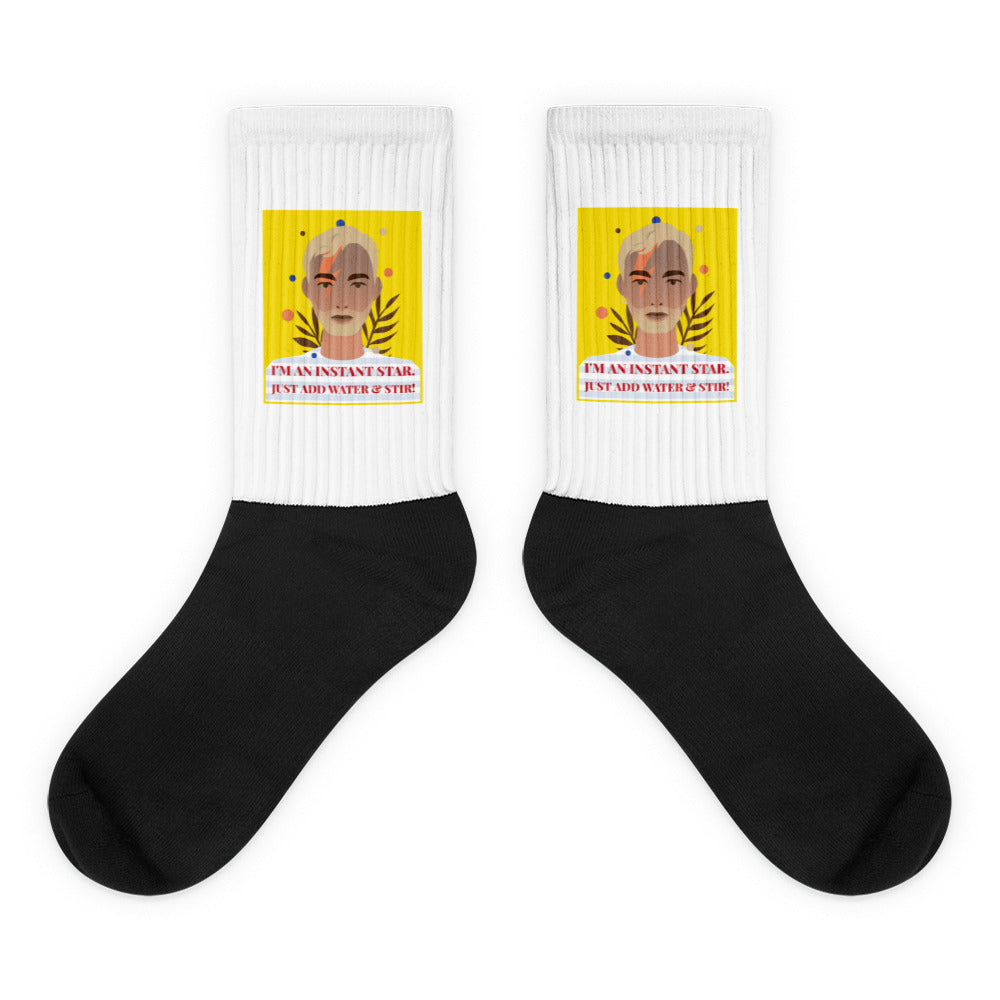 Pair of white-and-black socks with a colorful portrait and “I’M AN INSTANT STAR” text