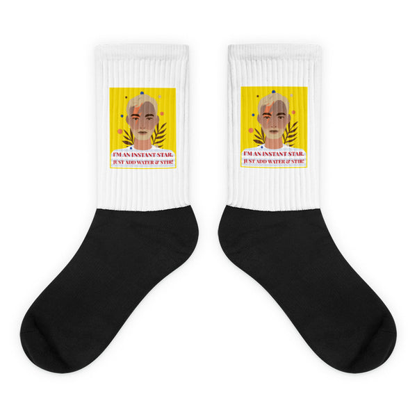 I'm An Instant Star Socks feature a bold black foot and vibrant white leg with a colorful portrait and slogan, celebrating queer pride and self-expression in a comfortable, stylish design.