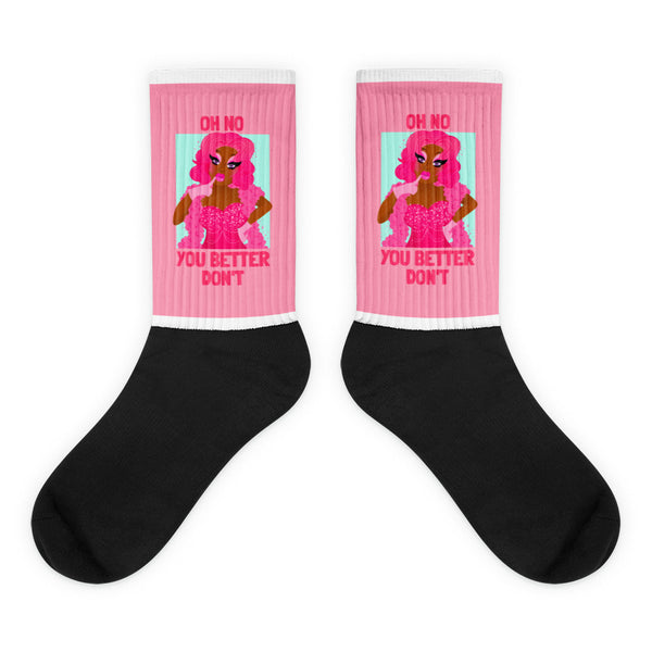 Oh No You Betta Don't Socks feature sassy pink illustrations on black and pink crew-length socks, blending bold style and comfort with a vibrant nod to LGBTQIA+ pride and self-expression.