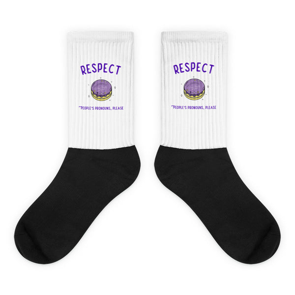 Respect People's Pronouns Please Socks feature white ribbed cuffs with “RESPECT” in purple, a macaron icon, and “people’s pronouns, please” slogan, celebrating pride and self-expression with bold, cushioned comfort.