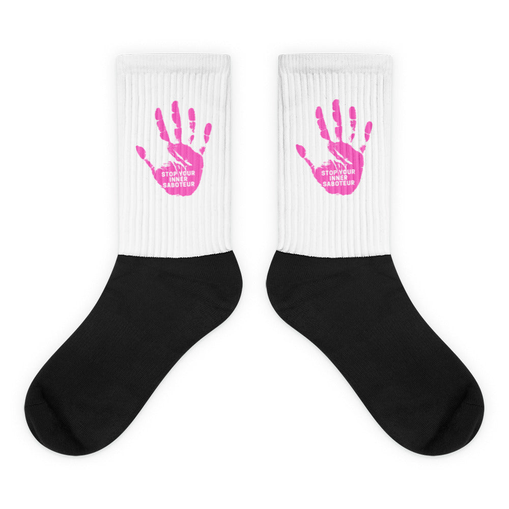 Pair of black-and-white crew socks with pink handprints and “STOP YOUR INNER SABOTEUR” text