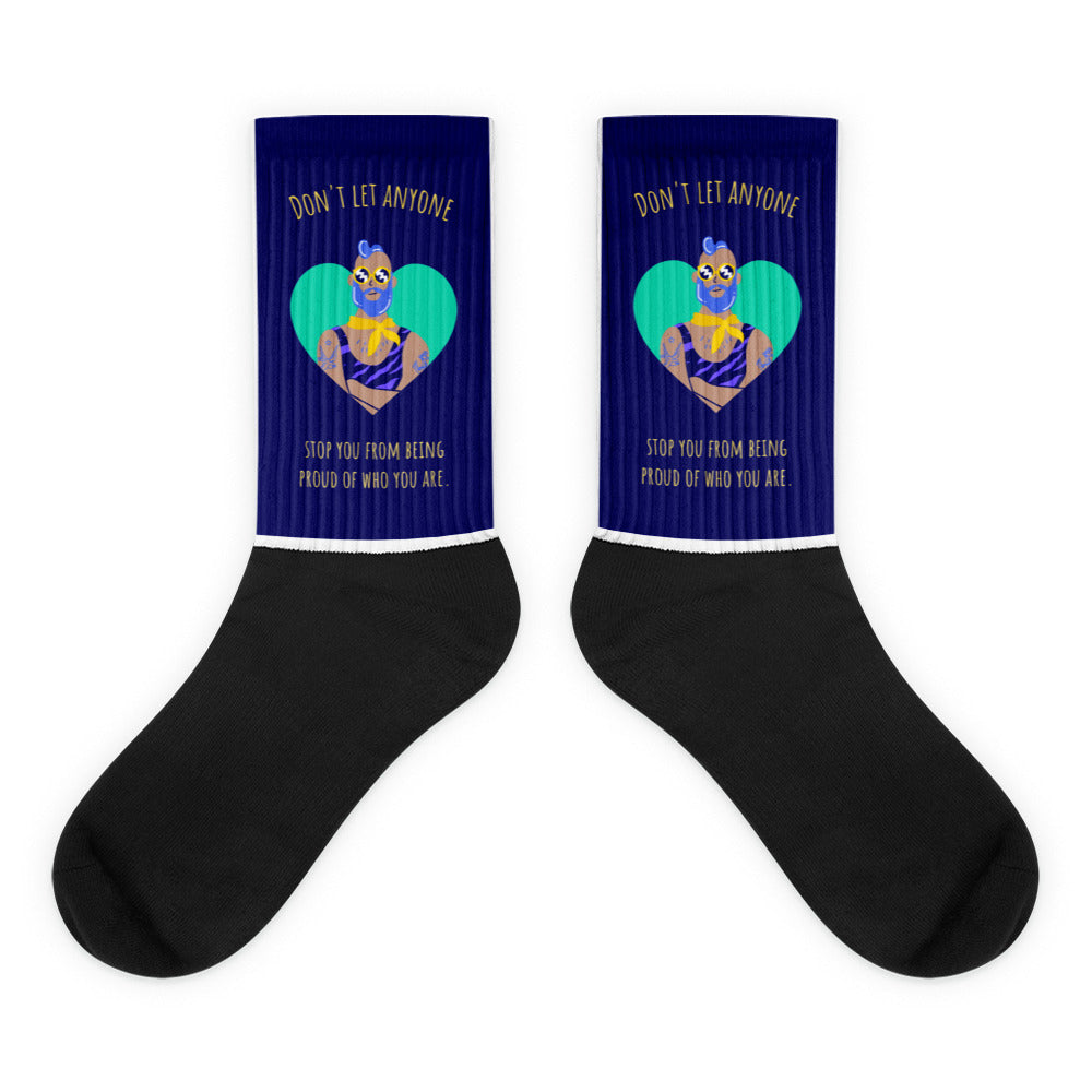 Pair of black and navy socks with a colorful masked figure, heart, and gold pride message
