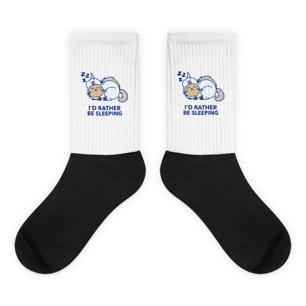 Pair of white-and-black crew socks with sleeping unicorns and “I'D RATHER BE SLEEPING” text