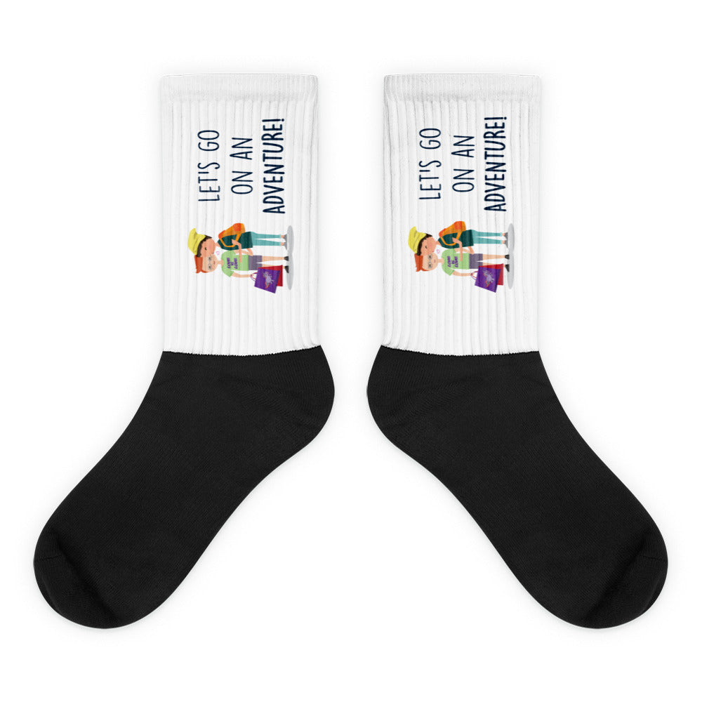 Pair of black-and-white socks with hikers and “LET’S GO ON AN ADVENTURE!” text