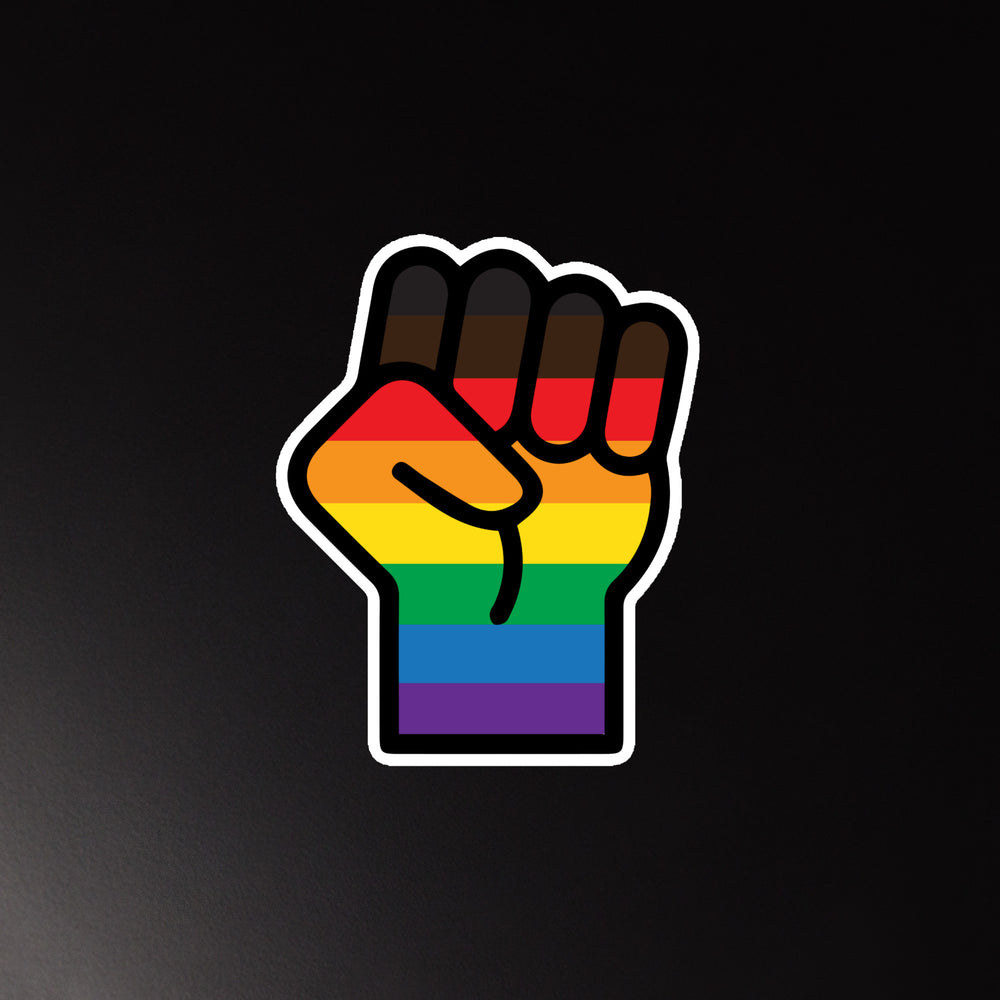 Raised fist magnet with horizontal rainbow Pride flag stripes on a black background