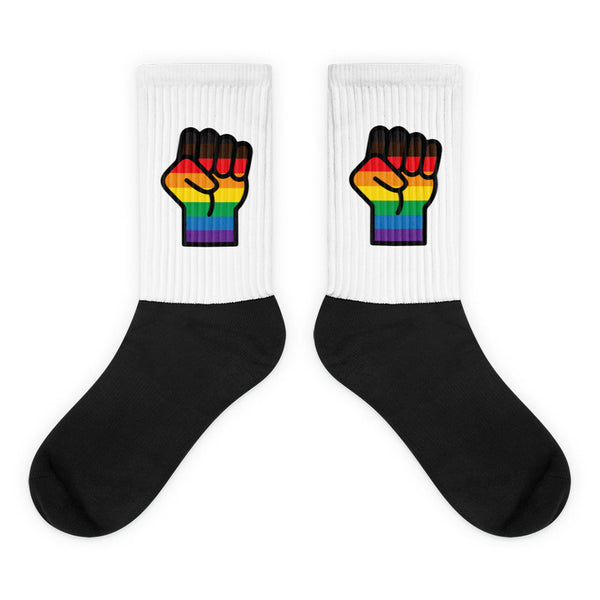 Pair of white crew socks with black feet and rainbow raised-fist graphics