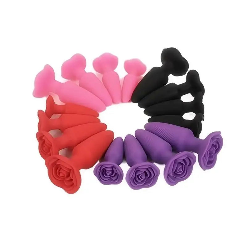Set of pink, red, purple, and black silicone anal plugs arranged in a circle