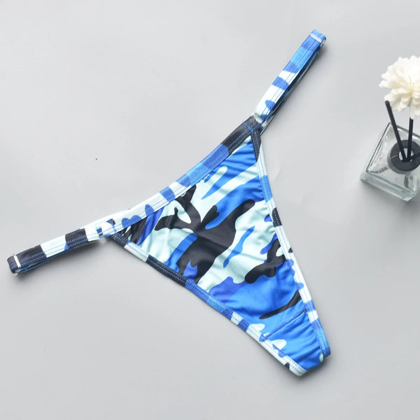 Blue, black, and white camouflage-patterned thong laid flat on a gray surface