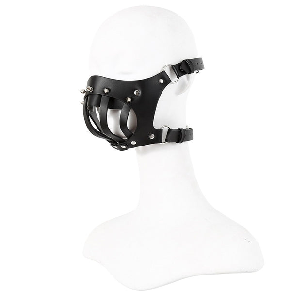 Black leather bondage muzzle with straps and metal studs on a white mannequin head