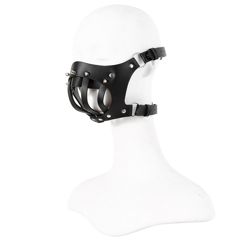 Black leather bondage muzzle with straps and metal studs on a white mannequin head