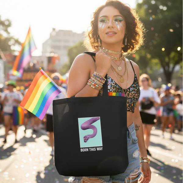 Person carries a black tote with a purple snake and “BORN THIS WAY” at a Pride parade