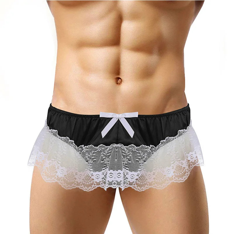 Front view of a model wearing black satin briefs with a white bow and wide white lace trim