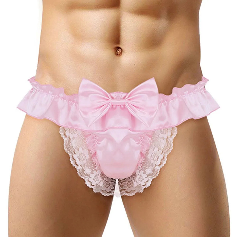 Front view of a model wearing pink satin panties with lace trim and a large bow