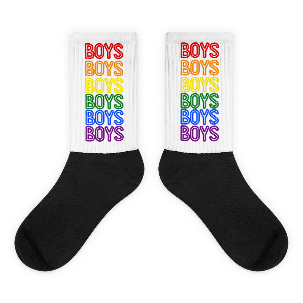 Pair of crew socks with black feet and white cuffs reading “BOYS” in rainbow colors