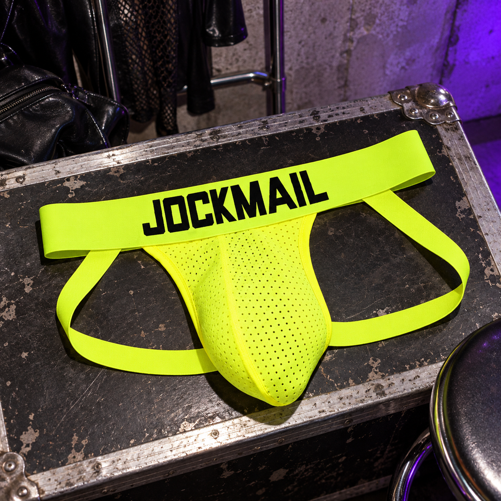 Jockmail Neon Party Jockstrap in Yellow, photographed at a charcoal wardrobe trolley in a concrete club dressing room.