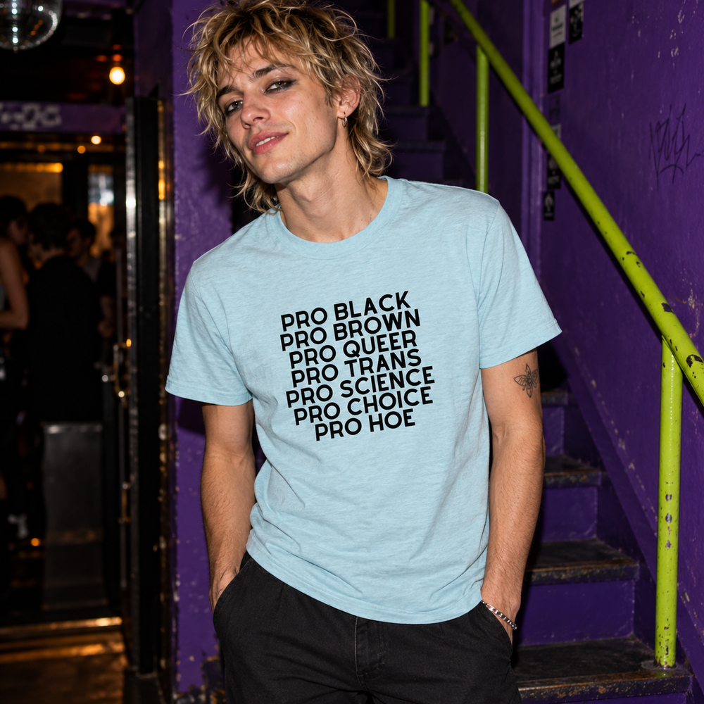 Pro Hoe (Black Text) T-Shirt in Heather Prism Ice Blue, worn at a violet-painted staircase with a narrow lime handrail.