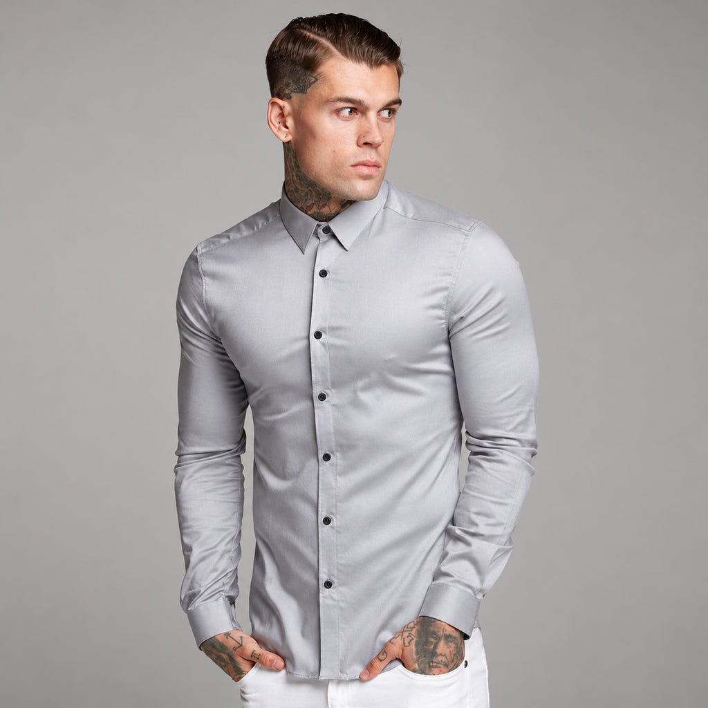 Front three-quarter view of a person wearing a fitted light gray long-sleeve button-up shirt